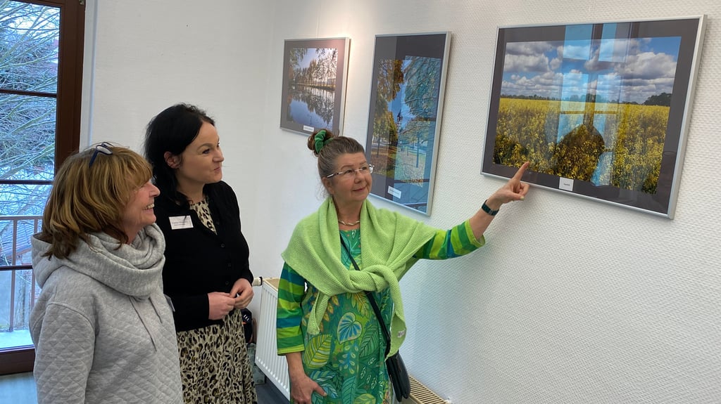 Karin Kinder (re.) präsentiert Marina Conradi (li.) und Yvonne Hillmann ihr Lieblingsbild in der Ausstellung.