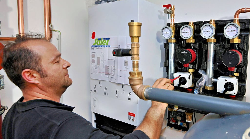 Ein Heizungsbauer stellt eine Wärmepumpe fachgerecht ein.  