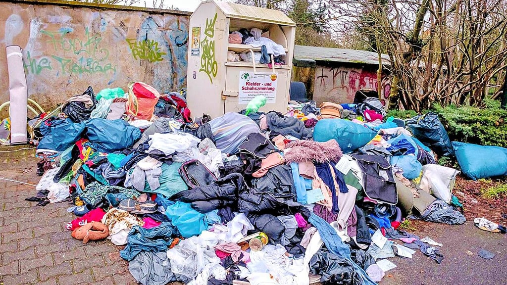 Vor dem Altkleidercontainer in Gräfenhainichen türmt sich ein Wäscheberg auf.