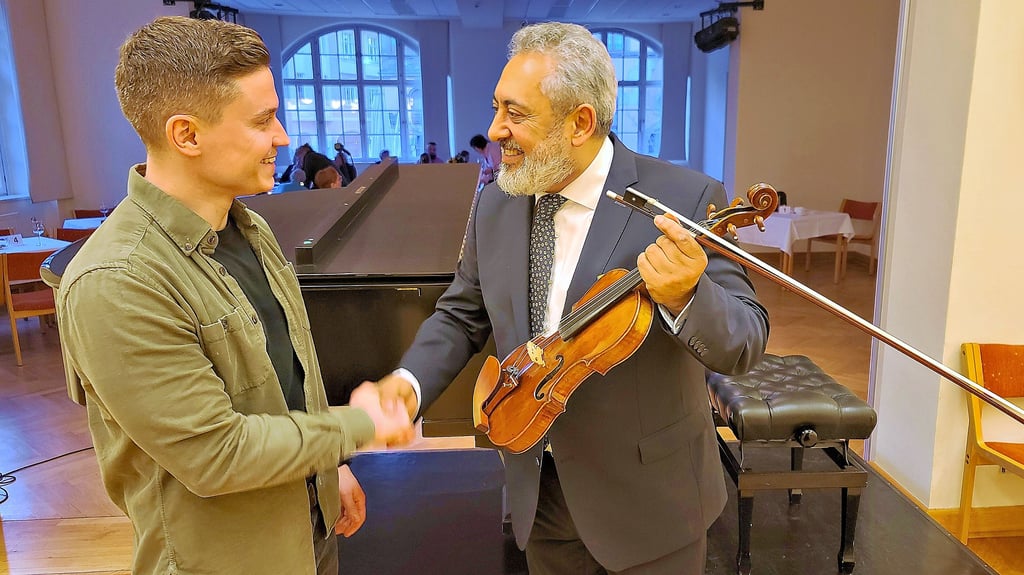 Cristian Goldberg (rechts) bedankt sich bei einem Konzert im Bestehornhaus bei Kriminalkommissar  Reinecke, der ihm die Violine wiederbrachte.