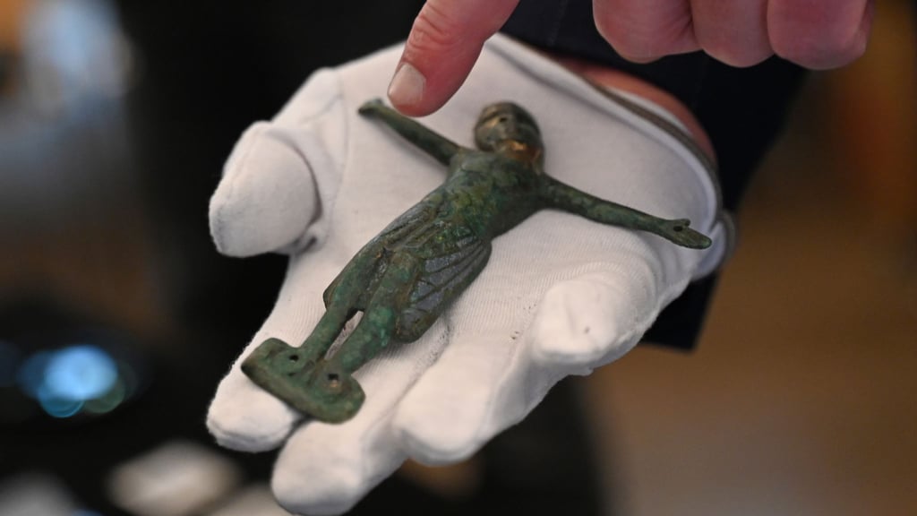 Felix Biermann, Projektleiter der archäologischen Untersuchung der Königspfalz Helfta, zeigt ein altes Kruzifix, das bei Ausgrabungen gefunden wurde.