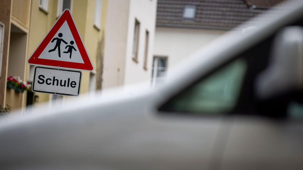 Ein Schild mit dem Schriftzug Schule und das dazugehörige Piktogramm, davor ein Pkw. Doch auf die Sicherheit der Schüler achten viele Eltern selbst nicht, wenn sie morgens ihre Kinder zur Schule bringen.