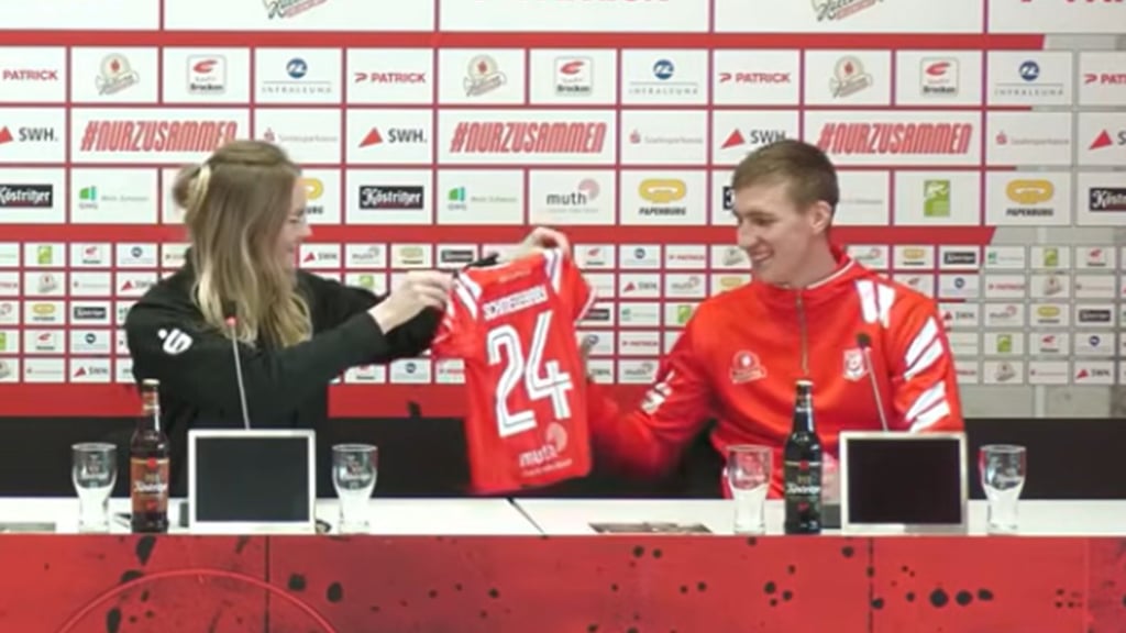 HFC-Pressesprecherin Lisa Schöppe überreicht Pascal Schmedemann das „Schmedebaby"-Trikot. 