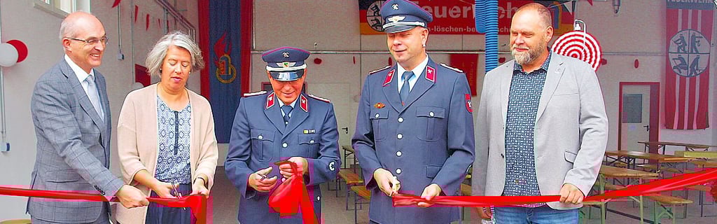 Zusammen mit Innenministerin Tamara Zieschang (2. von links) schnitt Fleetmarks Wehrleiter Andreas Herfort (3.  von links) im Juli 2025 das symbolische  Band an der Einfahrt zum neuen Feuerwehrgerätehaus durch. 