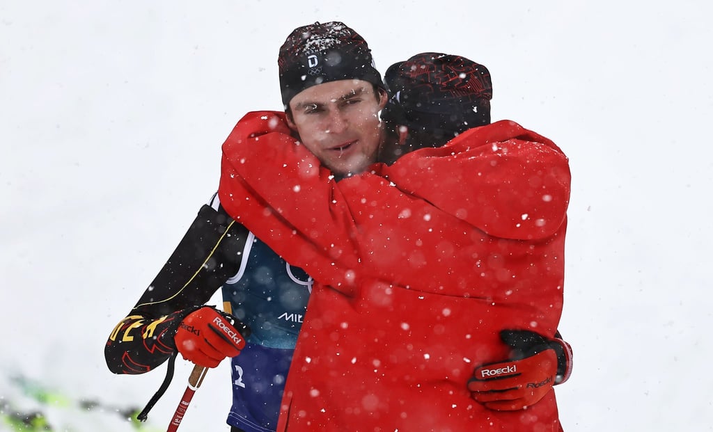 Kombinierer Vinzenz Geiger muss nach der vergebenen Olympia-Medaille von Johannes Rydzek getröstet werden.