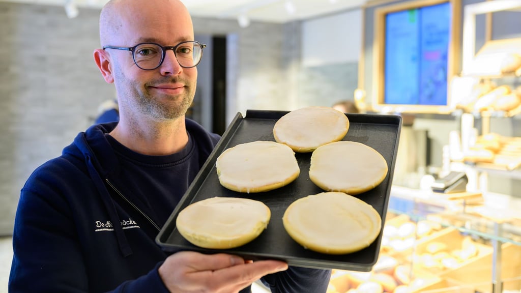 Jannik Harms, Geschäftsführer der De Heidbäcker GmbH, hält ein Blech „Grönländer“ in der Hand.