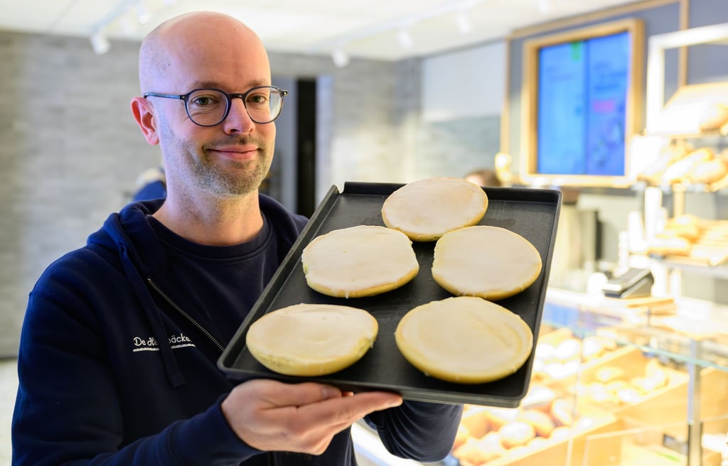 Jannik Harms, Geschäftsführer der De Heidbäcker GmbH, hält ein Blech „Grönländer“ in der Hand.