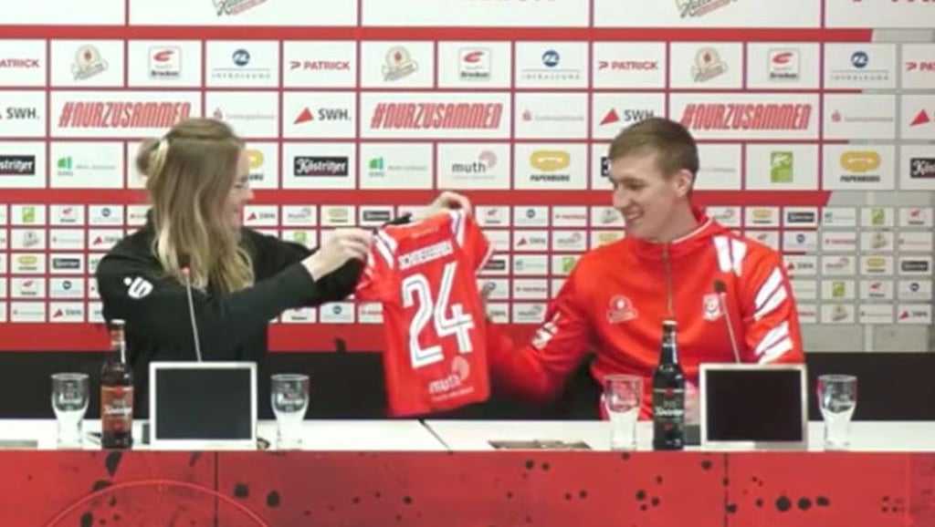 HFC-Pressesprecherin Lisa Schöppe überreicht Pascal Schmedemann das „Schmedebaby"-Trikot.