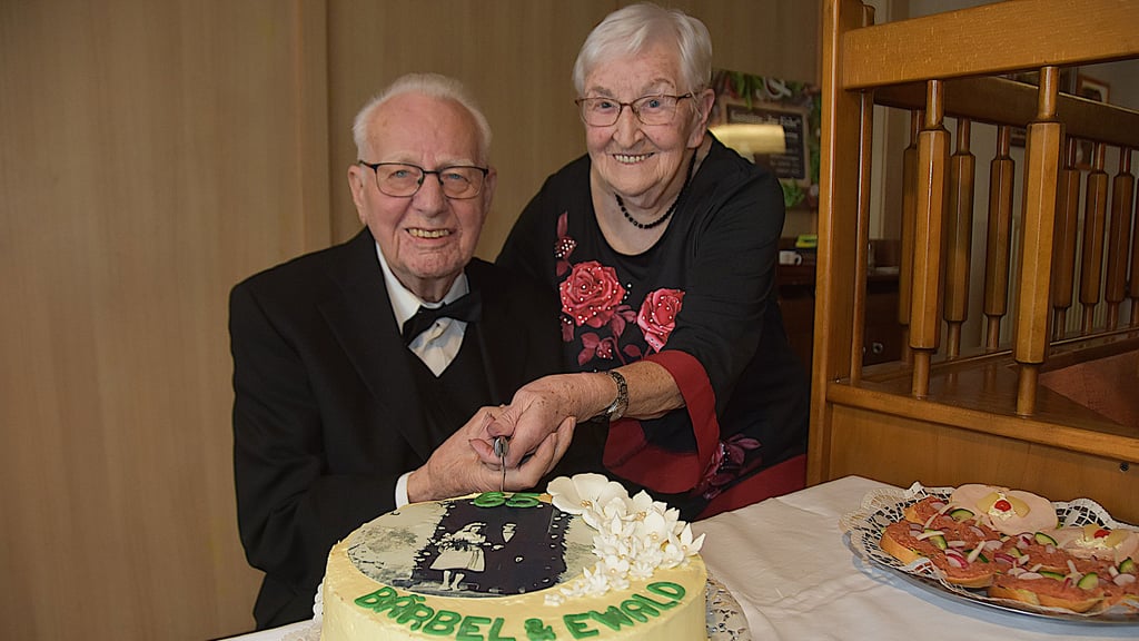 Gemeinsam schneiden Bärbel und Ewald Koch ihre Jubiläumstorte an – geschmückt mit ihrem Hochzeitsfoto von 1961. Seit 65 Jahren gehen sie Seite an Seite durchs Leben und feiern nun ihre eiserne Hochzeit.