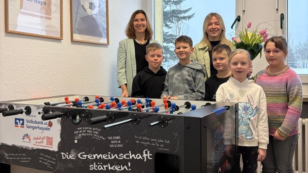 Schulleiterin Sandra Gießler (li.) und Klara Müller von der Volksbank freuen sich mit Ricky, Ludwig, Mattheo, Romi und Romy (v.l.) über den Tischkicker für die Grundschule Hayn.
