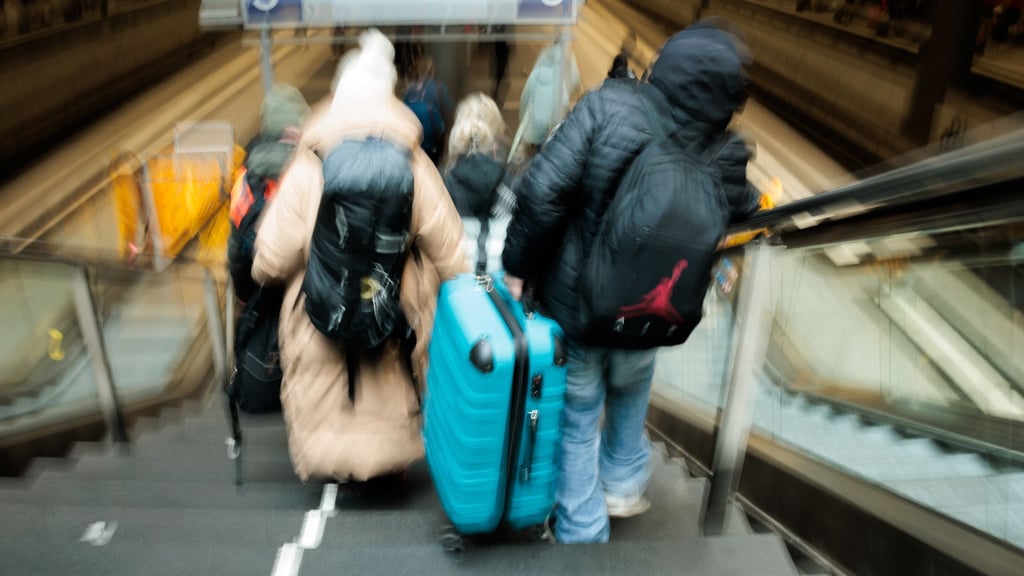 Reisende tragen auf dem Berliner Hauptbahnhof neben den gesperrten Rolltreppen große Koffer die Treppen hinab zum Bahnsteig.
