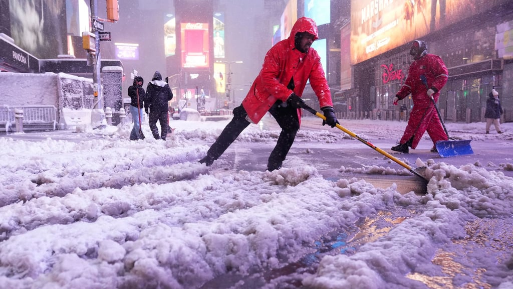 Ein Arbeiter schaufelt Schnee auf dem Times Square in New York. Ein heftiger Schneesturm zieht über den Nordosten der USA hinweg.