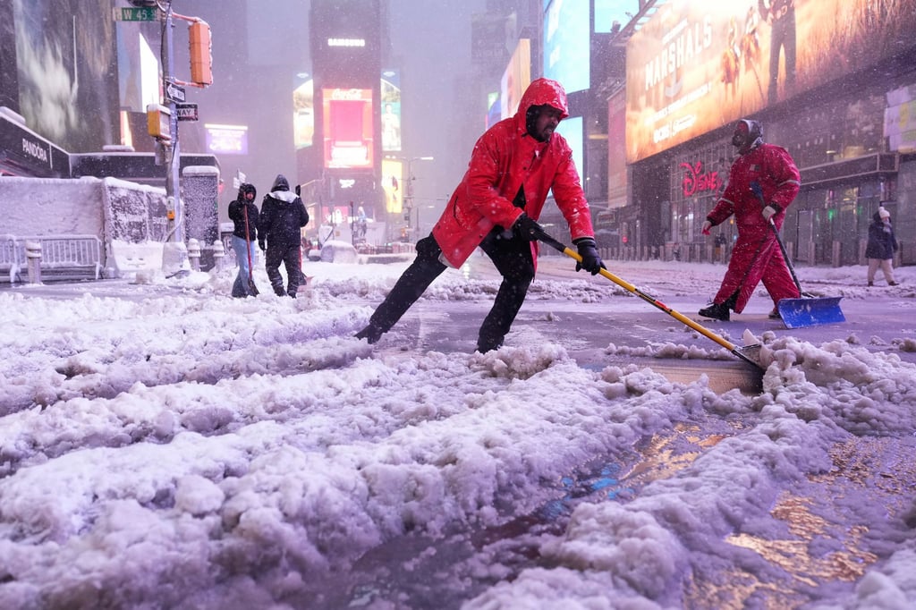 Ein Arbeiter schaufelt Schnee auf dem Times Square in New York. Ein heftiger Schneesturm zieht über den Nordosten der USA hinweg.