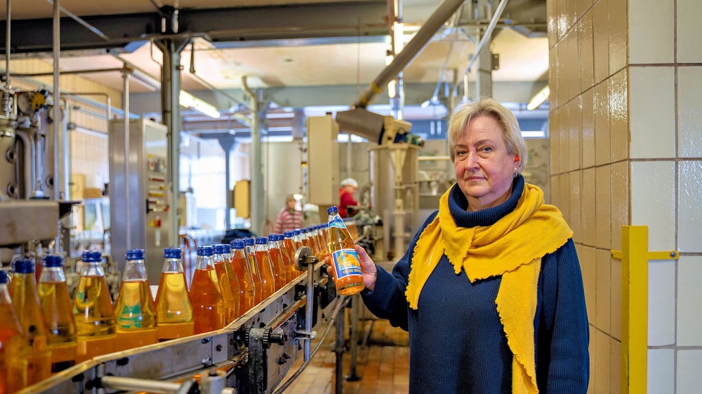 Neben der laufenden Abfüllanlage hält Geschäftsführerin Susann Danneberg den Bestseller der „Dinobrause“ in der Hand. Käme eine Zuckersteuer, wäre die Zukunft der Brauerei in Gefahr.&nbsp;
