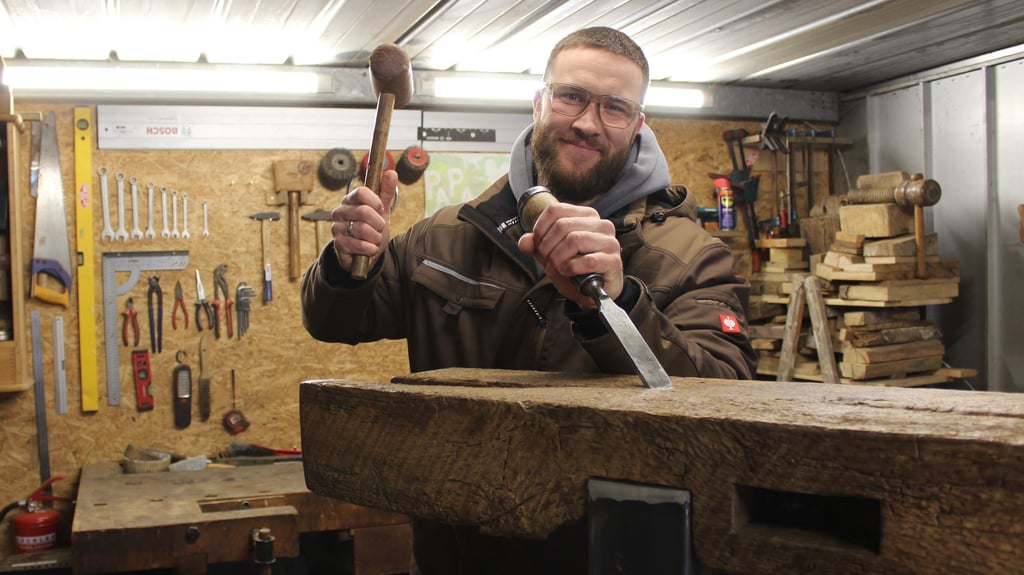 Der Hermsdorfer Martin Becker baut rustikale Holzmöbeln. In seinen Händen hält er einen Holzhammer und einen Stechbeitel - wie auch seinem Logo. 