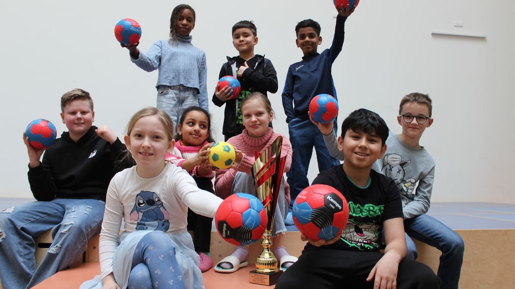 Die Gewinnerstaffel, bestehend aus Lisa (oben: v. l. n. r.), Wasif und Iyob, Caspar (Mitte: v. l. n. r.), Harerta, Lotta und Lenny sowie Paula (vorn links) und Ersatzläufer Kiyan, posiert für ein Gruppenfoto mit den Handbällen.