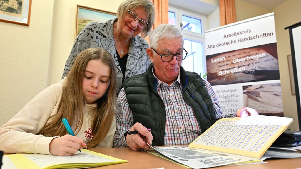 Im Sütterlin-Kurs lernen Enkelin Tamara und Großvater Heinrich Heckeroth zusammen, die alte Schrift auf das Papier zu bringen. Dozentin Birgit Tröße kontrolliert das Geschriebene.