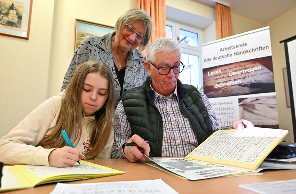 Im Sütterlin-Kurs lernen Enkelin Tamara und Großvater Heinrich Heckeroth zusammen, die alte Schrift auf das Papier zu bringen. Dozentin Birgit Tröße kontrolliert das Geschriebene.