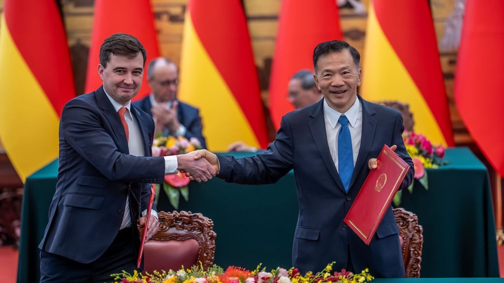 DFL-Geschäftsführer Steffen Merkel (l) und Shen Haixiong, Präsident der China Media Group CMG, nach der Unterzeichnung der Absichtserklärung.