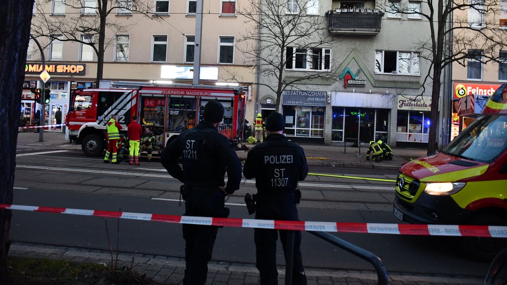 Polizisten sichern den Einsatzort bei einem der Brände in Magdeburg ab.
