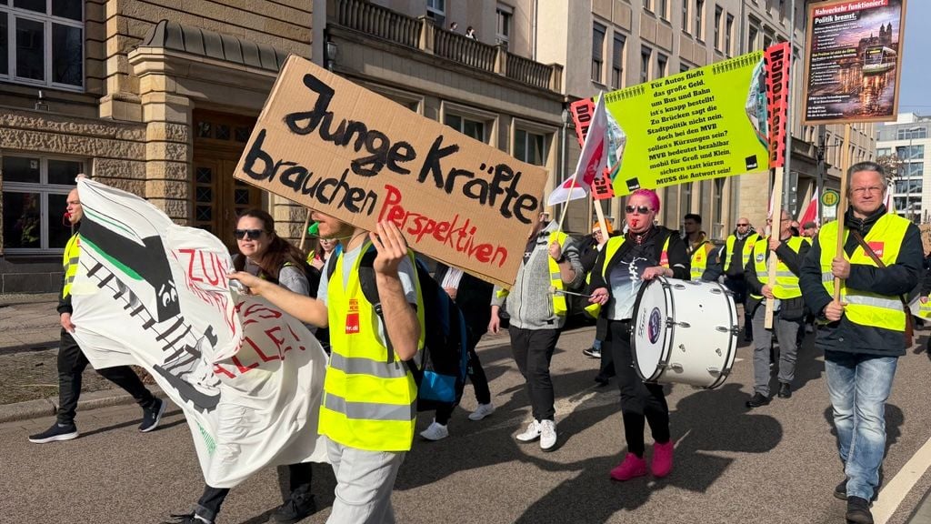 In einem Demonstrationszug ziehen am Donnerstag Streikende am Gebäude der Magdeburger Verkehrsbetriebe (MVB) vorbei. Die Gewerkschaft Verdi hat zum dreitägigen Warnstreik aufgerufen.