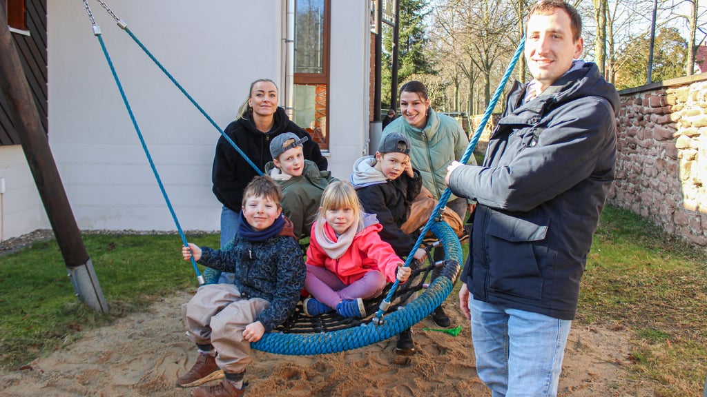 An der großen Schaukel der Kita „Märchenburg“ stehen die Erzieher Stephanie Konrad, Josepha Hagemeier und Erik Sommermeyer mit einigen Kindern. Der Erzieher ist zudem Springer im gesamten Stadtgebiet.