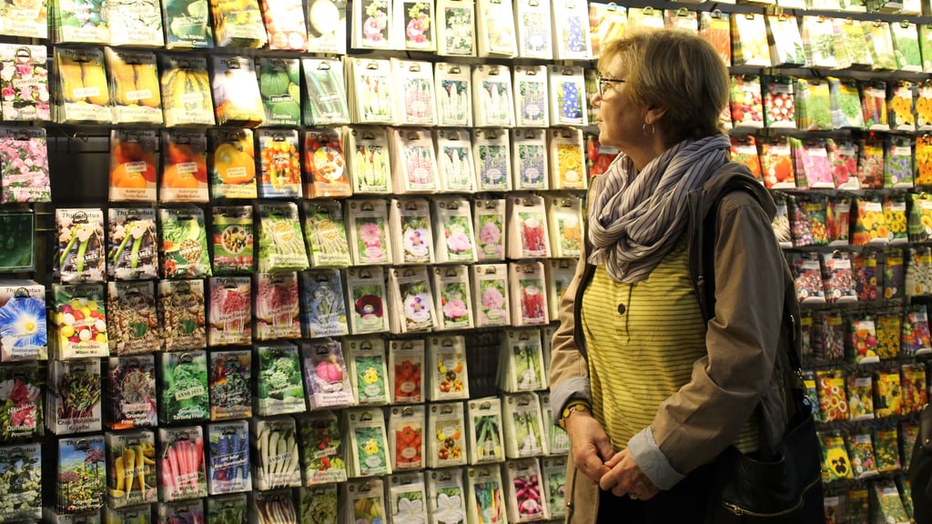 Eine Besucherin überblickt das große Saatgut-Angebot, das dieser Stand auf der Gartenträume-Messe zu bieten hat. 