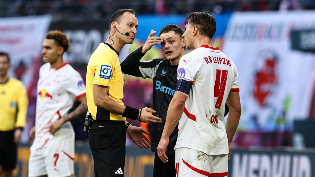 Referee Bastian Dankert spricht mit Florian Wirtz und RB-Profi Willi Orban (r.).
