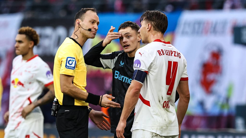 Referee Bastian Dankert spricht mit Florian Wirtz und RB-Profi Willi Orban (r.).
