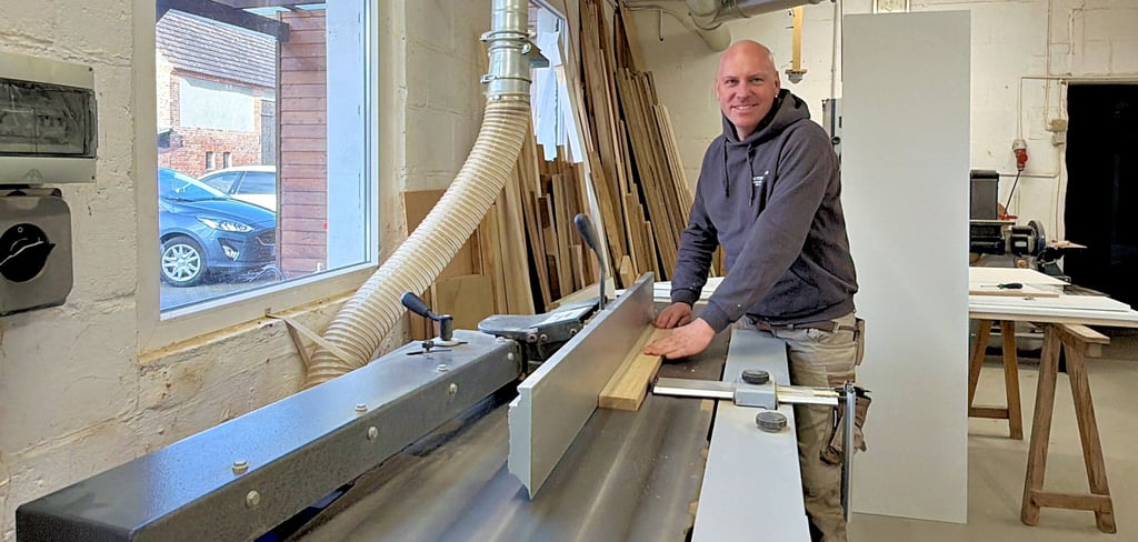 Sebastian Heinert am Hobel seiner Tischlerwerkstatt. Das Familienunternehmen Bautischlerei Heinert gibt es inzwischen seit 40 Jahren in Bertingen.