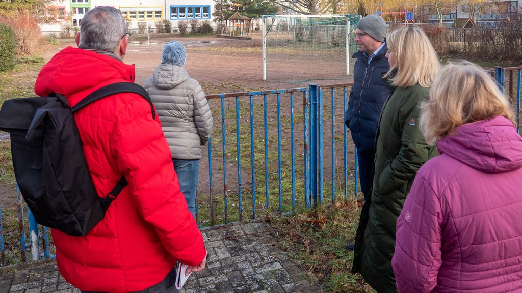 Rundgang mit dem Bürgermeister Phillip Stark (3.v.r.) in Burg-Süd - eine Volksstimme-Aktion. Hier wird der mit Löchern und Dellen übersäte Bolzplatz der Grundschule diskutiert.
