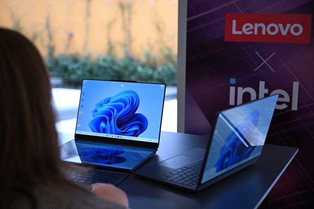 Zwei Lenovo-Laptops, die jeweils zwei Bildschirme haben: Rechts ist der zweite Bildschirm auf der Rückseite des ersten Bildschirms und links sind die beiden Bildschirme nebeneinander montiert - einer liegt vor der Tastatur und dahinter steht der zweite Bildschirm.