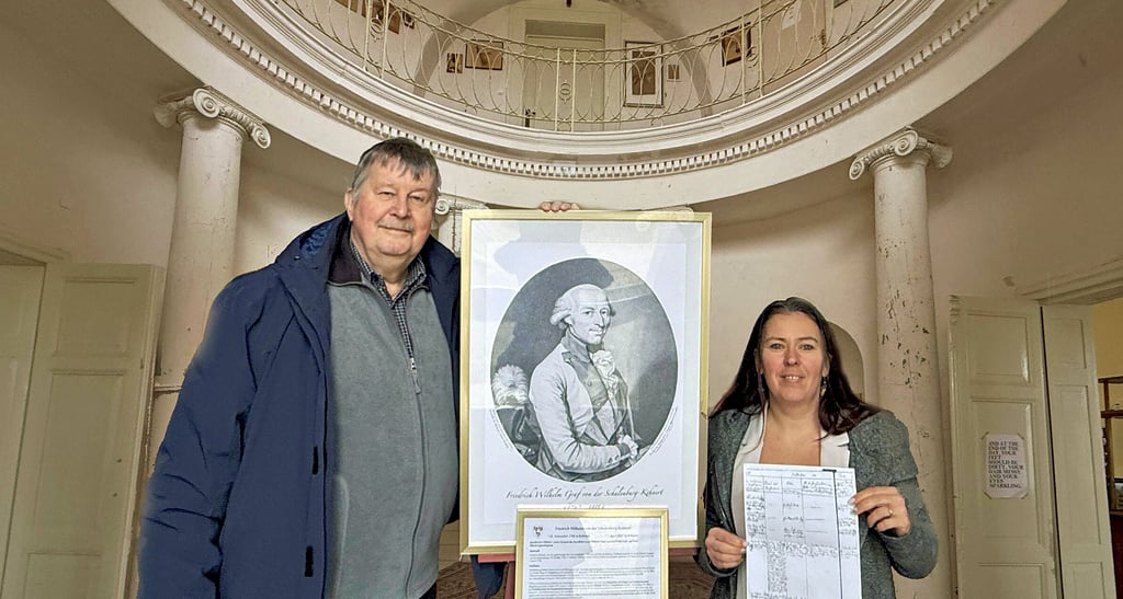 Jörg Mantzsch und Romina Göttler im Kehnerter Schloss mit dem Bild des Grafen Friedrich Wilhelm von der Schulenburg-Kehnert und Dokumenten, die seinen Beisetzungsort dokumentieren. 