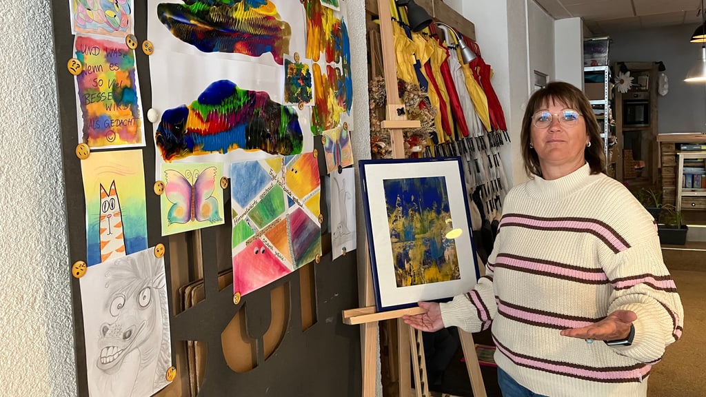 Citypastoral-Leiterin Anne Beck zeigt Arbeiten, die im Zeichenzirkel für Kinder und Jugendliche entstaanden sind.