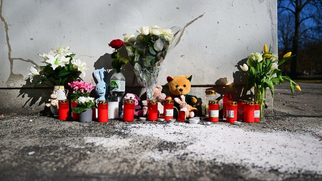 Blumen und Beileidsbekundungen liegen in Berlin-Marzahn an der Stelle, an der gestern ein Kind aus 15. Stock gestürzt ist.
