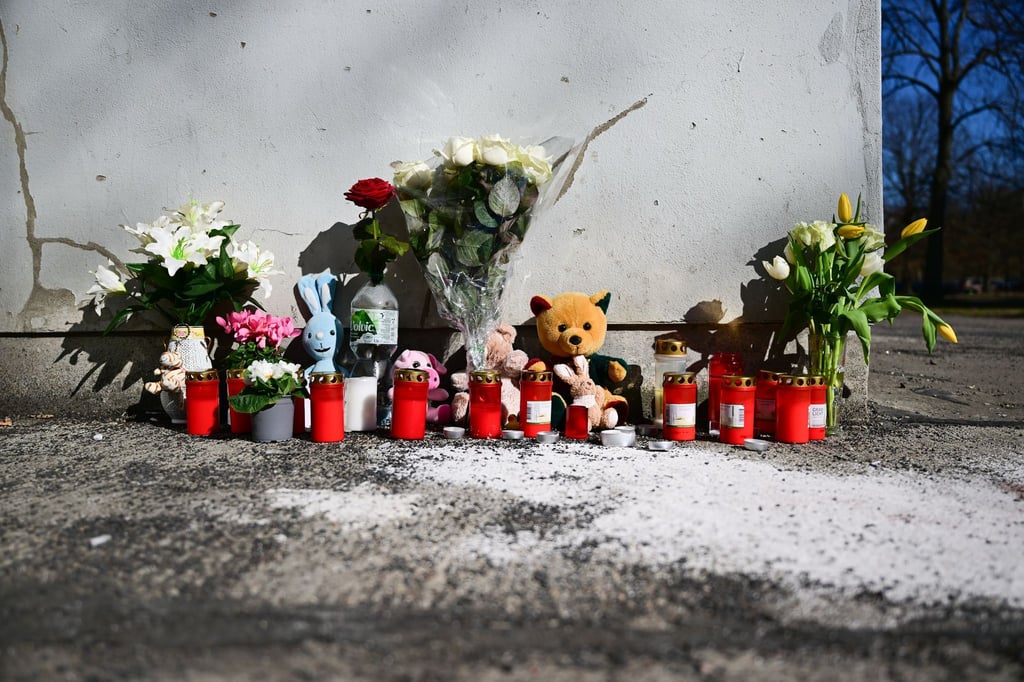 Blumen und Beileidsbekundungen liegen in Berlin-Marzahn an der Stelle, an der gestern ein Kind aus 15. Stock gestürzt ist.