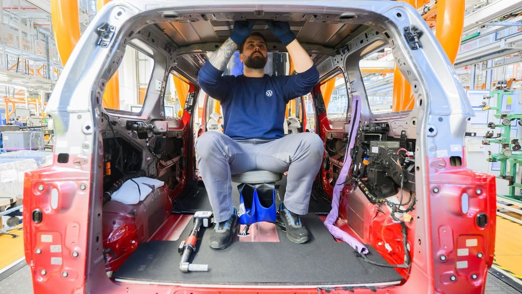 Ein Mitarbeiter montiert einen Elektro-Bulli ID. Buzz im Werk von Volkswagen Nutzfahrzeuge.