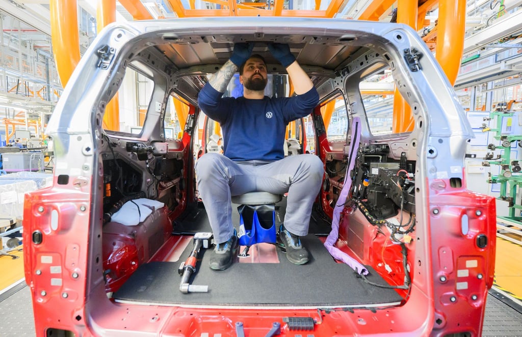 Ein Mitarbeiter montiert einen Elektro-Bulli ID. Buzz im Werk von Volkswagen Nutzfahrzeuge.