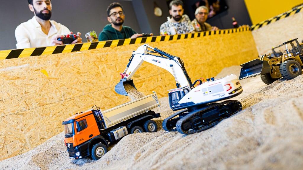 Gründer Siymo Othman (links) steuert mit Freunden kleine Bagger, Radlader und Lastwagen in seinem neu eröffneten Bagger-Café. Es soll das erste dieser Art in Deutschland sein.