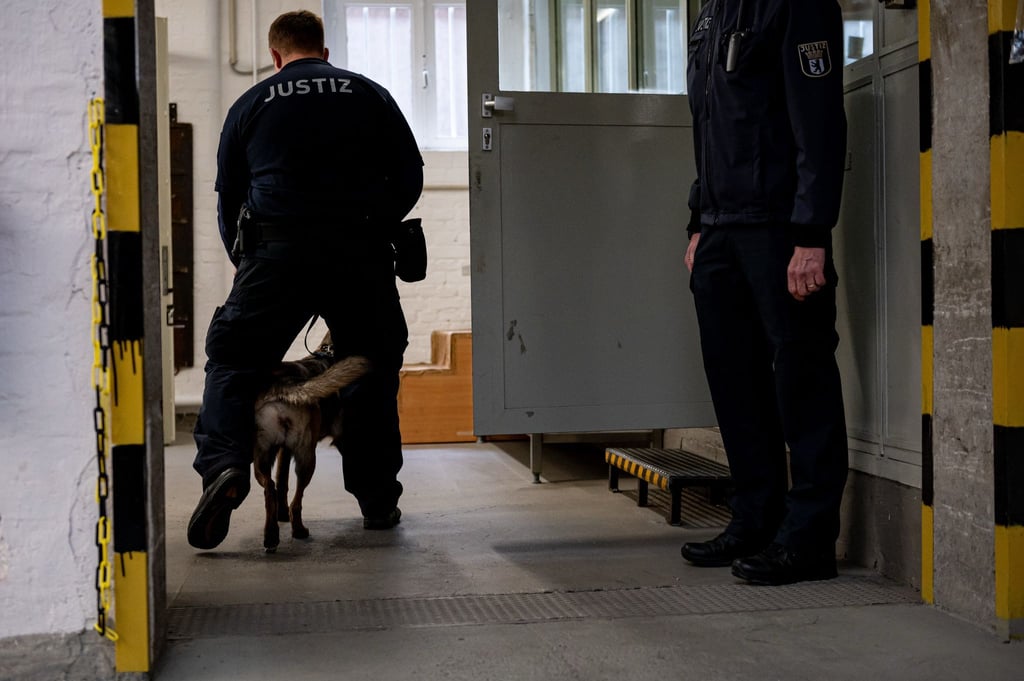 Ein Hund der justizeigenen Hundestaffel läuft mit einem Justizbeamten in der Justizvollzugsanstalt Tegel. (Archivbild)