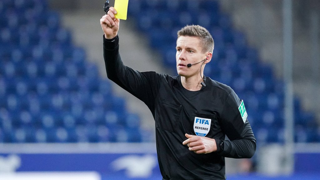 FIFA-Schiedsrichter&nbsp;Daniel Siebert verteilt eine gelbe Karte.