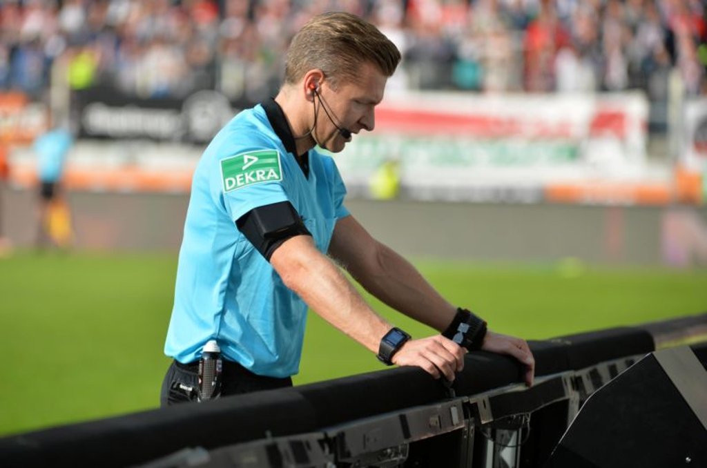 Wenn es mal wieder länger dauert: Schiedsrichter Tobias Welz beim Videobeweis bei FC Augsburg gegen RB Leipzig.