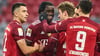 Robert Lewandowski (r.) und Thomas Müller (3.v.r.) freuen sich mit Dayot Upamecano über sein erstes Tor für den FC Bayern.