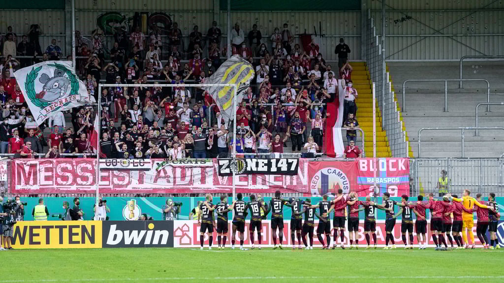 Die Spieler von RB Leipzig feiern vor dem eigenen Fanblock mit den mitgereisten Fans.