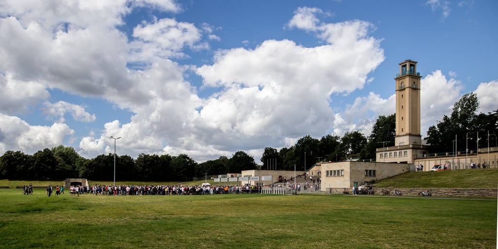 Leipzigs Fans stehen am Eingang auf der Festwiese und warten auf Einlass ins Stadion.