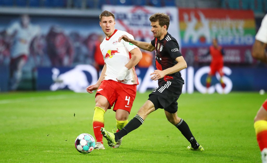 Willi Orban (l.) spielt einen Pass, bevor sich Thomas Müller vom FC Bayern den Ball schnappen kann.