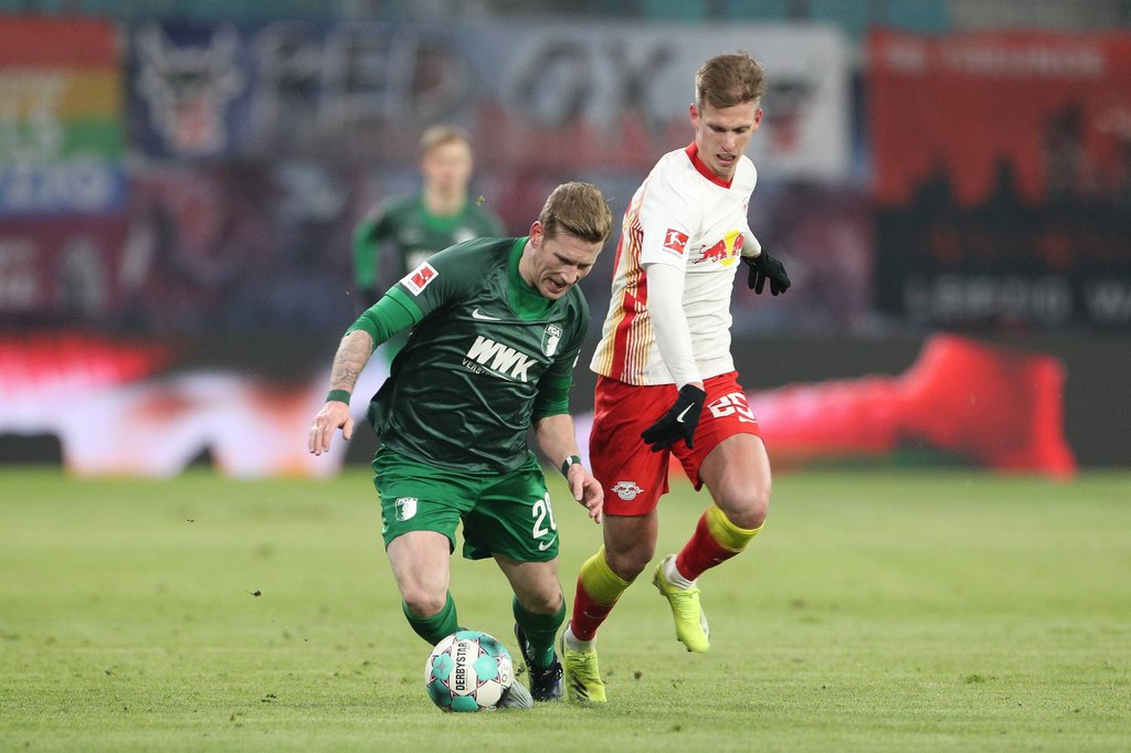 RB Leipzigs Dani Olmo verfolgt Augsburgs André Hahn (l.).