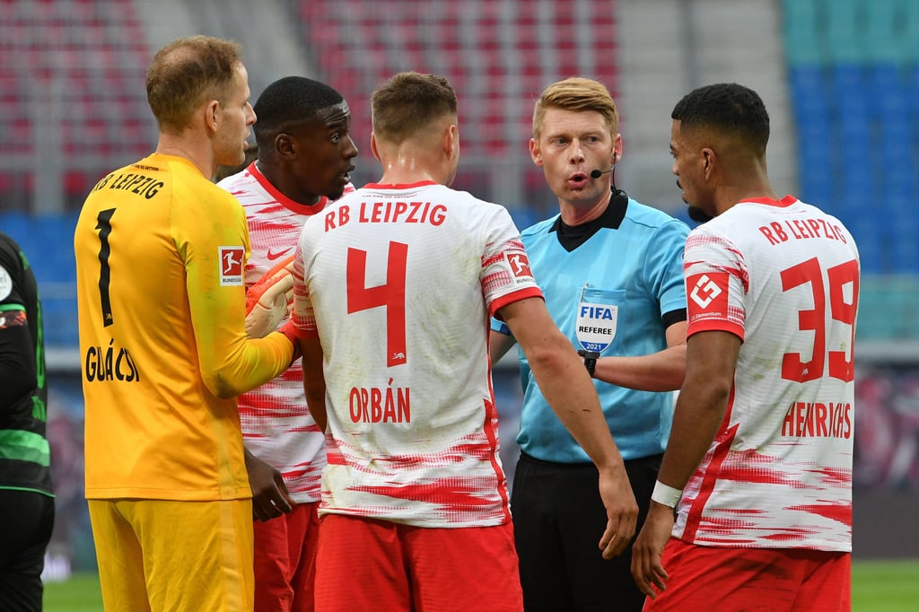 Das soll Elfmeter sein? Leipziger Spieler umlagern Schiedsrichter Christian Dingert.