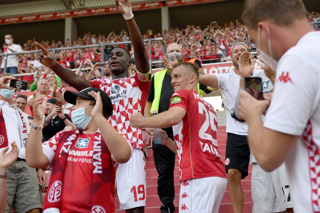 Der Mainzer Kapitän Moussa Niakhate feiert in Mitten der Fans. Der DFB hat nun eine Geldstrafe gegen den Klub verhängt.